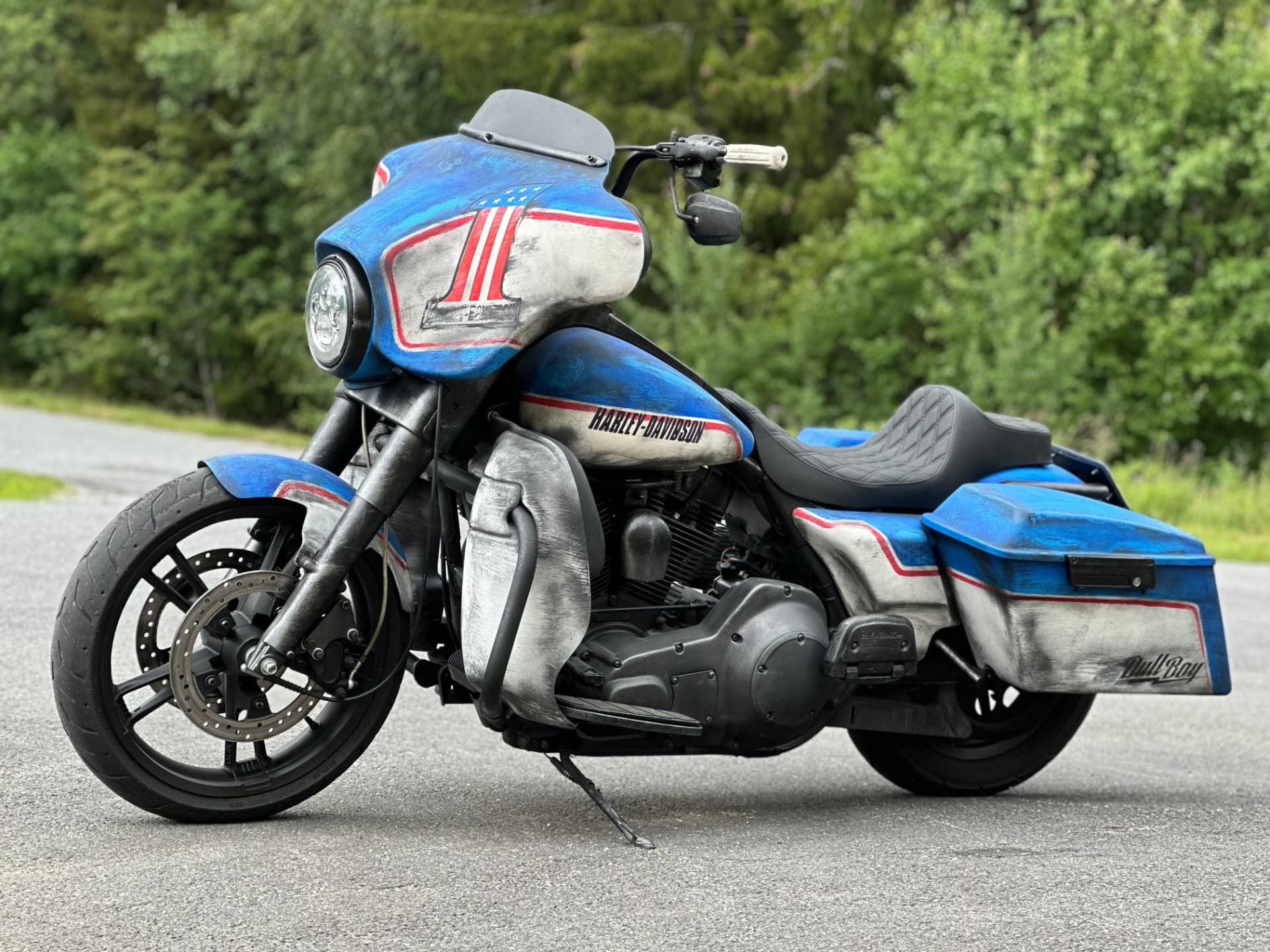Blue and bare metal Harley bagger with hand-painted number one fairing