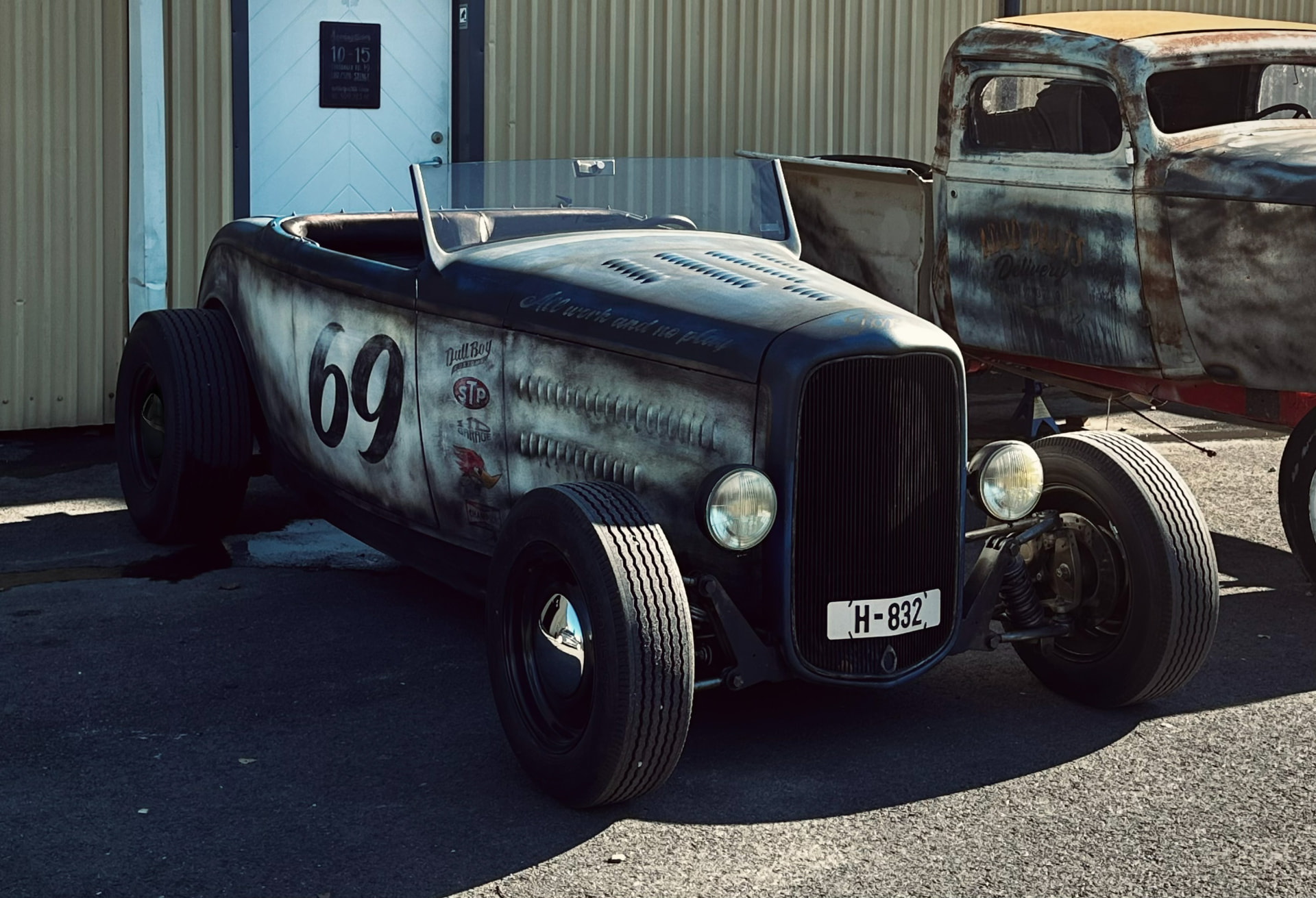 '32 Ford Roadster in the sun with a bare Ford body behind it