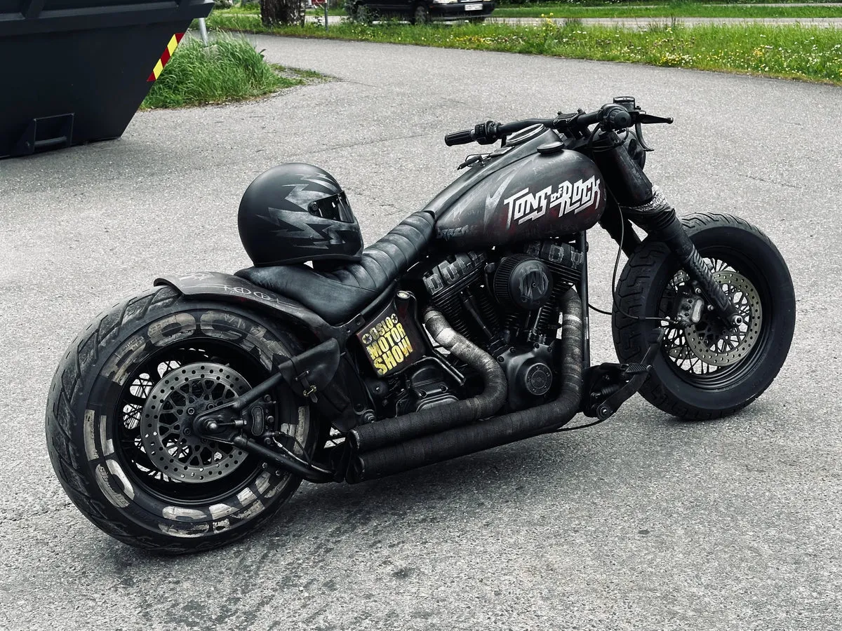 Tons of Rock custom motorcycle — a Harley-Davidson Softail Night Train painted with band logos from the 2024 Tons of Rock festival.