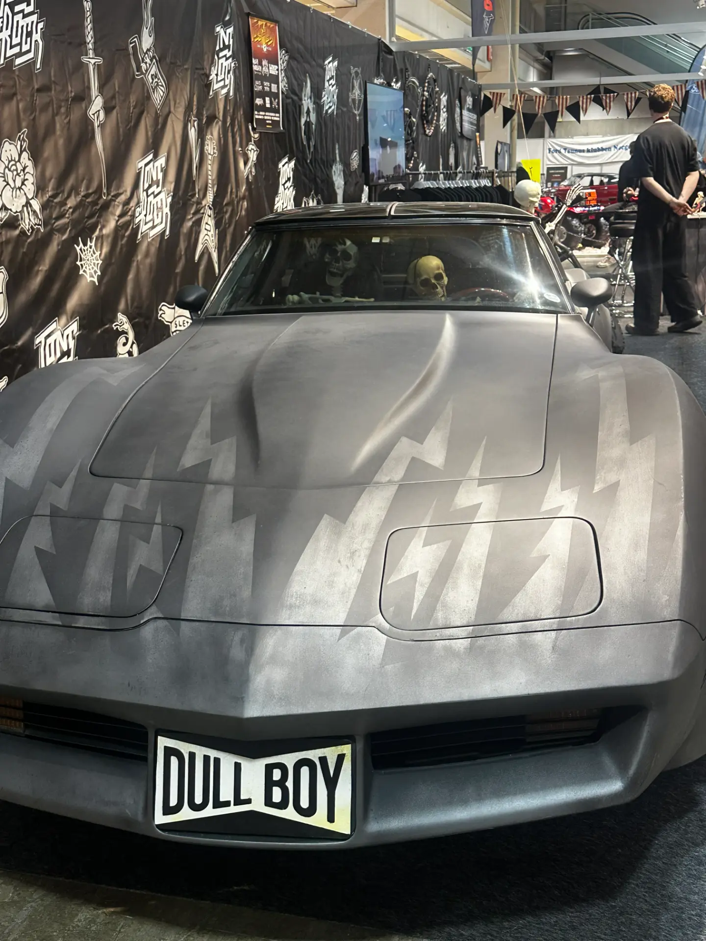 Matte grey Dull Boy car with lightning bolt graphics and skulls on display