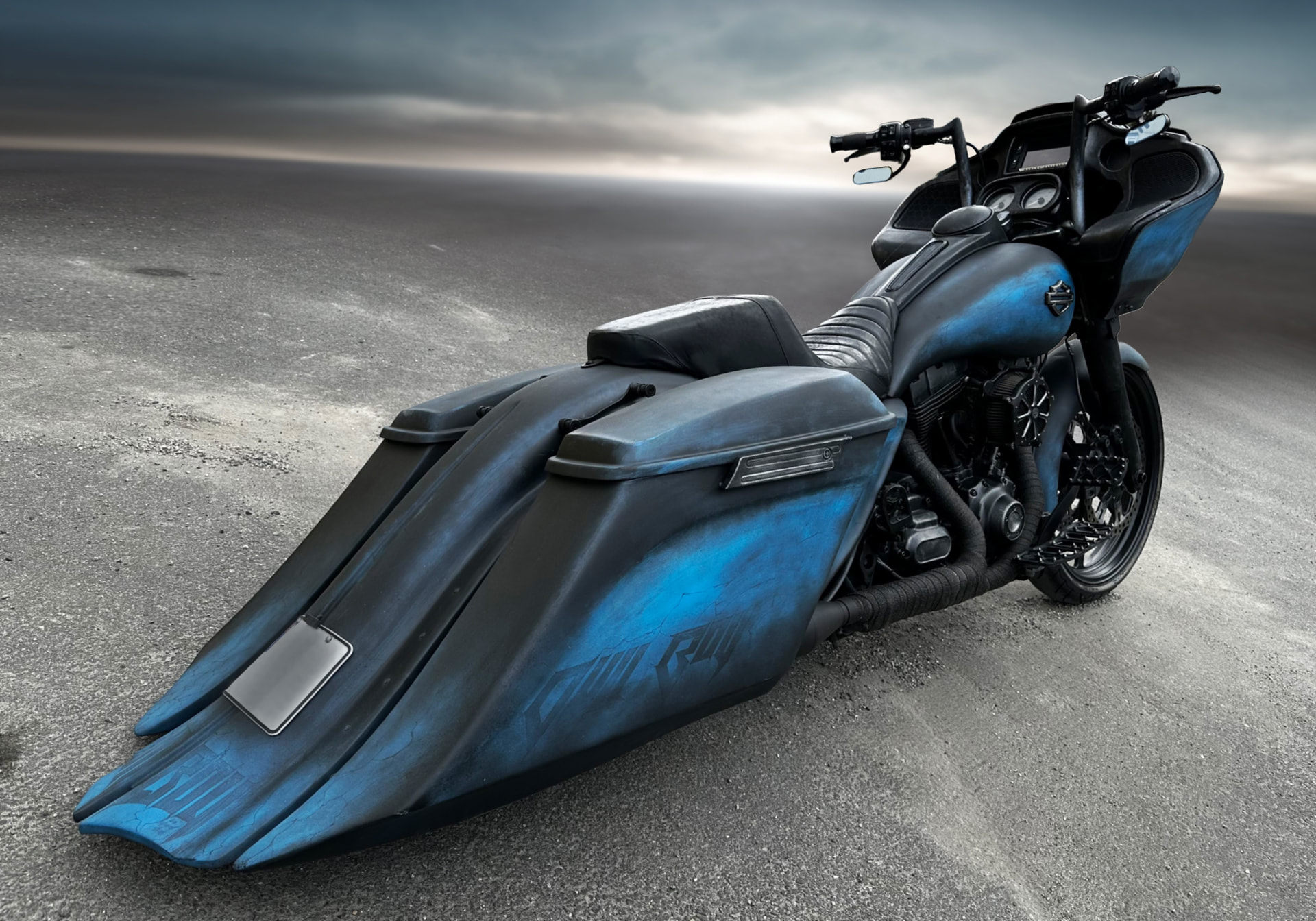 Weathered blue and black custom Harley bagger with stretched bags