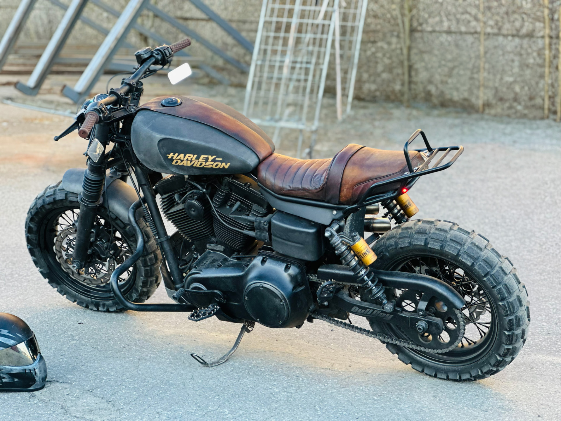 Black Harley-Davidson scrambler with brown leather seat and knobby tyres