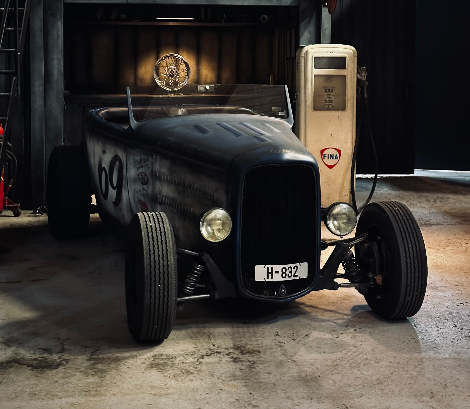 Front view of the '32 Ford Roadster beside a vintage Fina fuel pump
